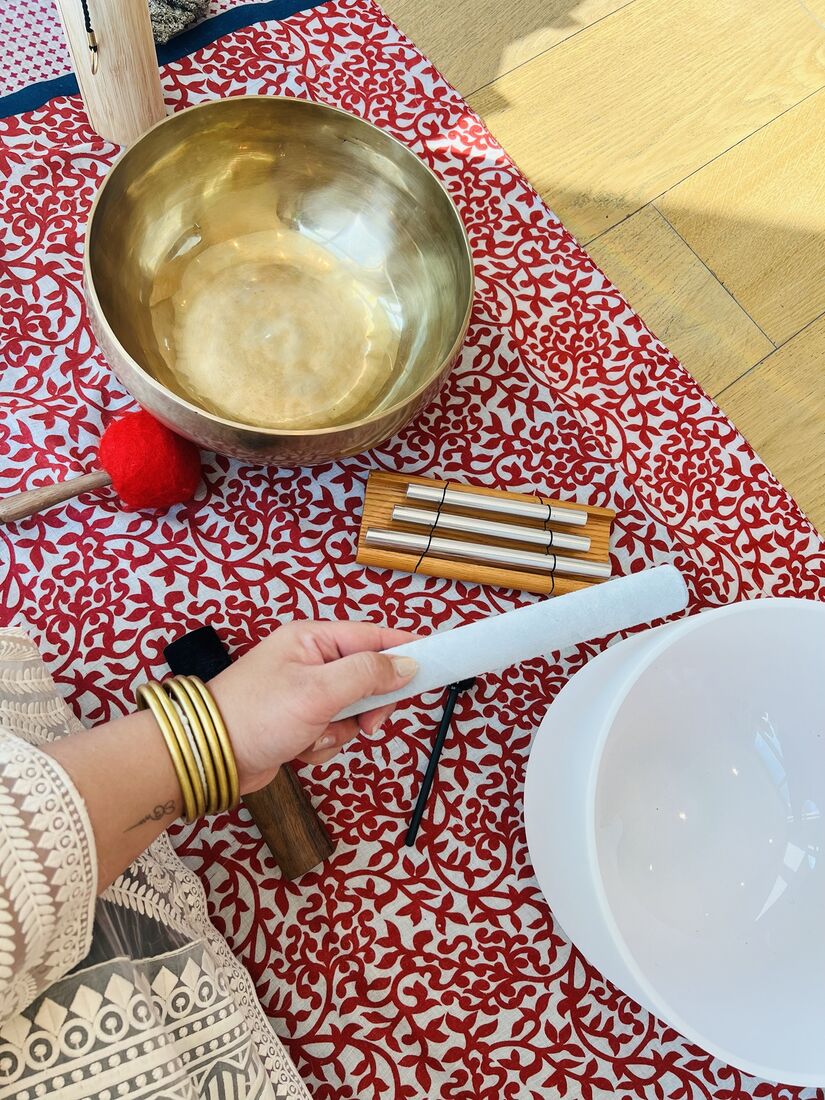Tibetan singing bowl, chimes and crystal bowl on a red textile