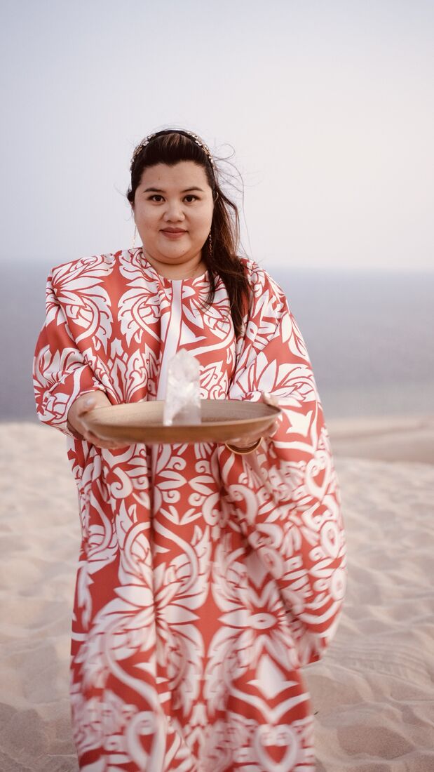 Vivi offering a quartz crystal on a brass tray in the desert