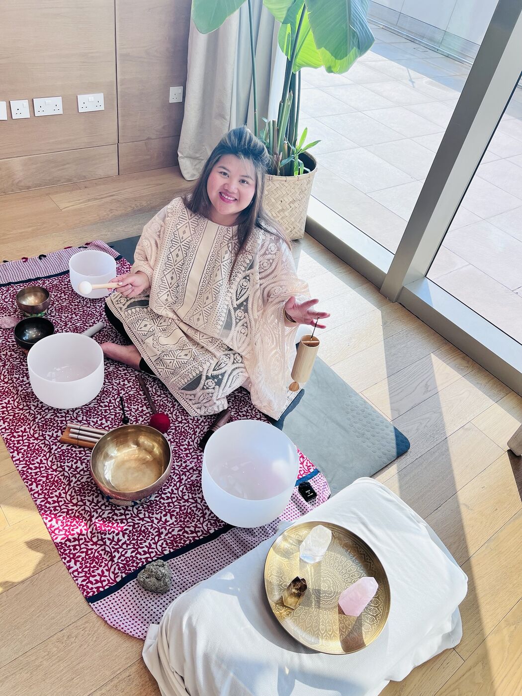 Vivi setting up crystal and Tibetan singing bowls for a session in a hotel suite